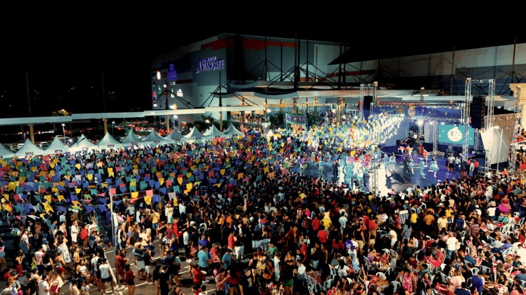 O Arraial da Alegria 2026 já tem data para movimentar a agenda cultural de Manaus. O evento será realizado entre os dias 28 de maio e 28 de junho, sempre de quinta-feira a domingo, no Shopping Manaus ViaNorte, com entrada gratuita e uma estrutura renovada para receber o público. Neste ano, a principal novidade será a mudança de espaço. A programação junina passará a ocupar o estacionamento próximo à entrada do Salomé Grill, em uma área mais ampla, planejada para oferecer mais conforto, segurança e comodidade aos visitantes. De acordo com a coordenação de marketing do shopping, a mudança acompanha o crescimento registrado pelo evento nas últimas edições, que teve aumento no fluxo de visitantes e consolidou o arraial como uma das programações tradicionais do período junino na capital amazonense. “O Arraial da Alegria já é um evento muito esperado pelo público e, neste ano, pensamos em um espaço que pudesse receber as famílias com mais conforto e comodidade. A mudança acompanha o crescimento do arraial e vai permitir uma experiência ainda melhor para quem participar da programação”, destacou Karoline Cordeiro, coordenadora de marketing do empreendimento. Arraial da Alegria 2026 terá programação gratuita por um mês O Arraial da Alegria 2026 vai reunir gastronomia típica, apresentações de danças tradicionais, espaço kids e shows com artistas locais durante um mês de programação. A proposta é atender diferentes públicos, com atrações voltadas para crianças, jovens e adultos. Segundo a organização, a edição deste ano mantém a proposta de valorizar as tradições juninas e oferecer opções de lazer acessíveis para as famílias de Manaus, agora com uma estrutura ampliada. “Será um mês inteiro de programação pensado para reunir as famílias, com atrações para diferentes idades e um ambiente preparado para receber o público com conforto. Oferecer uma programação gratuita e acessível é algo que valorizamos muito”, completou Karoline. Serviço — Arraial da Alegria 2026 Evento: Arraial da Alegria 2026 Local: Shopping Manaus ViaNorte Endereço: avenida Arquiteto José Henrique Bento Rodrigues, bairro Monte das Oliveiras Período: de 28 de maio a 28 de junho de 2026 Dias: quinta-feira a domingo Entrada: gratuita Atrações: comidas típicas, danças juninas, espaço kids e shows locais Novo espaço: estacionamento próximo à entrada do Salomé Grill